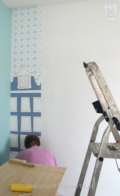 Eerste baan behang zit op de nieuwe wand in nieuwbouwhuis